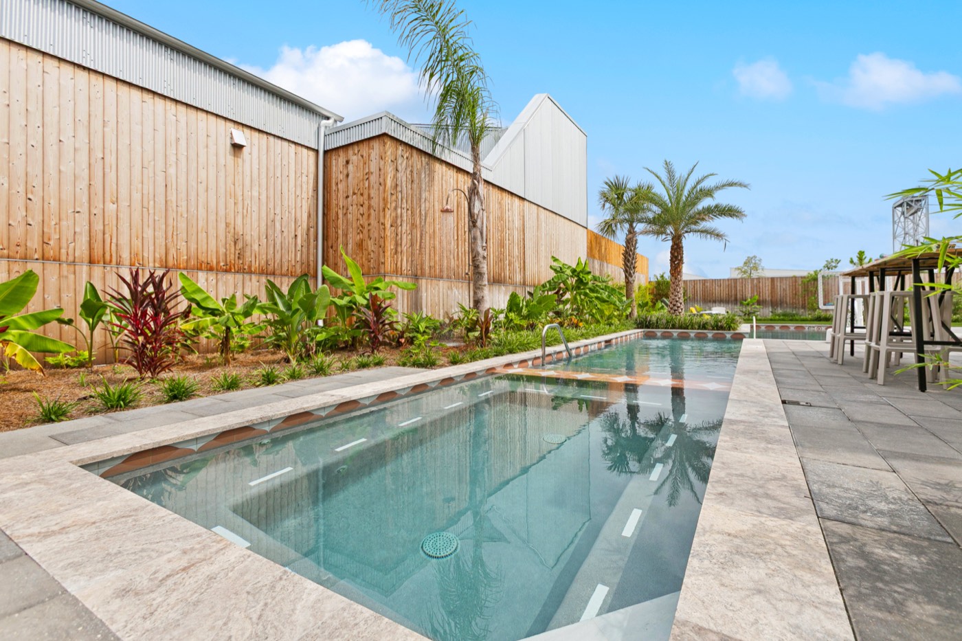 Long heated pool with tropical landscaping at Castleday Retreats in the Bywater
